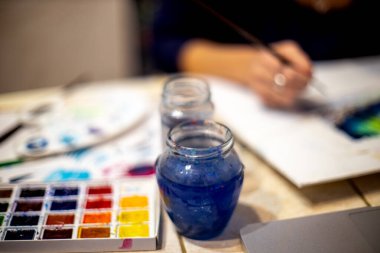 Paletli ve tuvalli bir sanatçının masaüstü. Yüzeyin derinliği