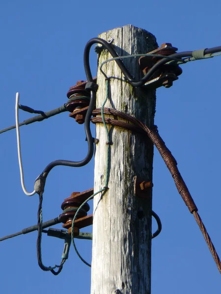 老木电报/电线杆与生锈的金属电缆对深蓝色的天空 — 图库照片