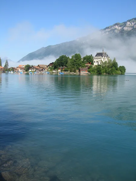 Widok na jeziorem Brienzersee szwajcarskiej tradycyjnej, rybackiej miejscowości Iseltwald na słonecznej wczesnym latem rano — Zdjęcie stockowe