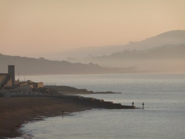 Sunrise atış bir puslu Lyme Regis ve erken sonbahar Dorset Sahili
