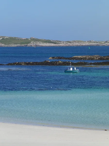 Spiaggia Caolas, isola di Tiree, con piccola barca ormeggiata al largo nelle acque blu-verdi — Foto Stock
