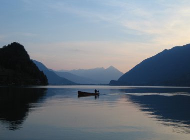 Small fishing boat on Brienzersee, Switzerland at dusk clipart