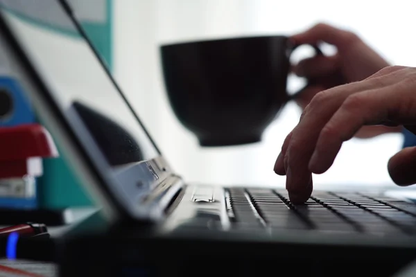 Am Laptop arbeiten und Kaffee trinken — Stockfoto