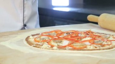 Şef pizza hazırlar. Pişirme pizza. Malzemeler hamur koyar.