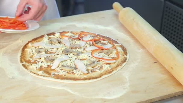 El chef prepara la pizza.La pizza para cocinar. Pone los ingredientes en la masa . — Vídeo de stock