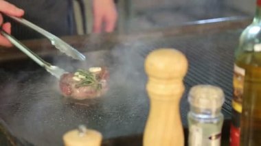 Şef ızgara biftek ızgara. Aşçıya eti pişirir. Biberiye ve sarımsak et. Biftek döner. Yemeğin hazırlanması. Restoran. Gıda. Mermer et. Sulu ihale et.