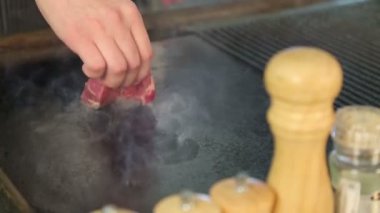 Şef ızgara biftek ızgara. Aşçıya eti pişirir. Biberiye ve sarımsak et. Biftek döner. Yemeğin hazırlanması. Restoran. Gıda. Mermer et. Sulu ihale et.