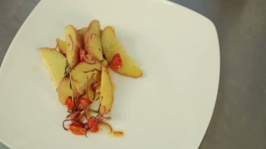 Şef biftek yemeği koyar. Biftek üzerine garnitür. Et ile garnitür. Biftek. Beyaz yemek. Bitmiş çanak dekorasyon. Patates, soğan, domates. Üstten Görünüm.