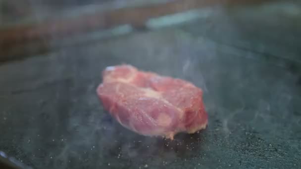 Szakács a grillezés a grill a steak. A szakács sültek a húst. A rozmaring és a fokhagymát a hús. Bekapcsolja a steak. Az izzítótégelyek előkészítése. Étterem. Élelmiszer. Márványos hús. Lédús pályázati hús. — Stock videók
