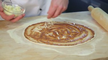 Şef pizza hazırlar. İnce hamur. Mutfakta Restoran. Domates, peynir, sosis, domates salçası, zeytin, biber. Pizza için malzemeler. Un.
