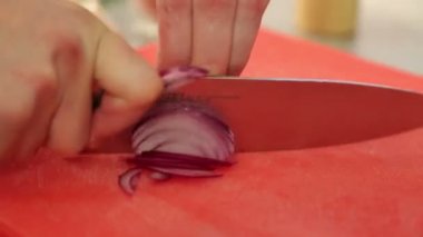 Şef soğan dilimleri. Bıçak, yönetim kurulu, soğan kesme. Hızlı kesme sebze. Soğan yarım halkalar. Kızartma için soğan. Aşçı eller.