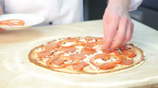 El chef prepara la pizza.Dona delgada.La cocina en el restaurante. Los tomates, queso, salchichas, pasta de tomate, aceitunas, pimientos. Los ingredientes para la pizza. Harina . — Vídeo de stock