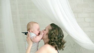 Anne çocukla çalış. Genç aile. Altı aylık çocuk ve anne. Mutlu anne. Anne ve oğlu eğlenceli sahip. Çocuk gülümsüyor.