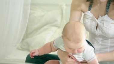 Anne çocukla çalış. Genç aile. Altı aylık çocuk ve anne. Mutlu anne. Anne ve oğlu eğlenceli sahip. Çocuk gülümsüyor.