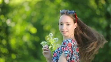 Uzun saçlı genç baştan çıkarıcı kız ormanda günbatımı üzerinde poz.