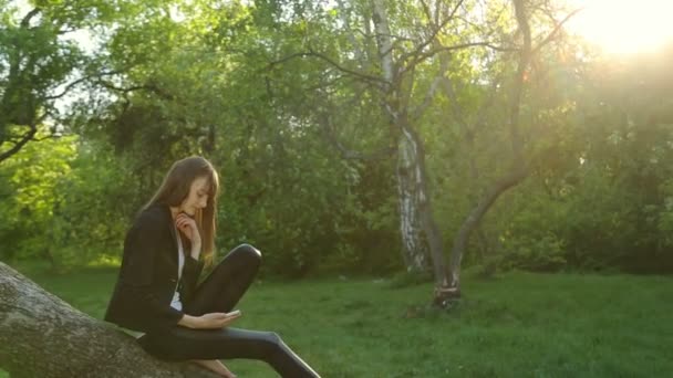 Schönes Mädchen macht Selfie bei Sonnenuntergang am Baum im Wald. — Stockvideo