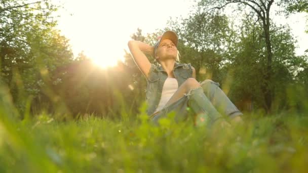 Menina bonito em jeans roupas posando contra o pôr do sol . — Vídeo de Stock