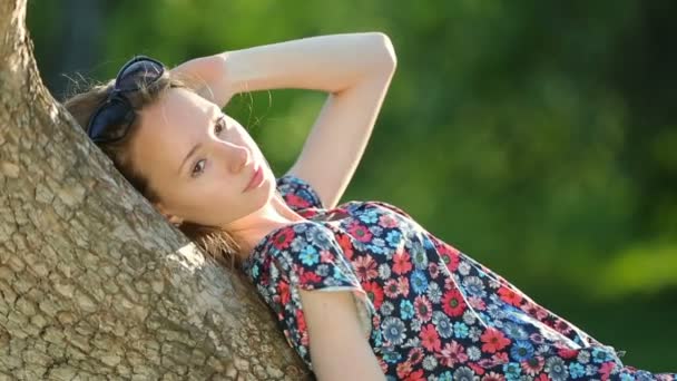 Beautiful girl posing at sunset at the tree in the forest. — Stock Video