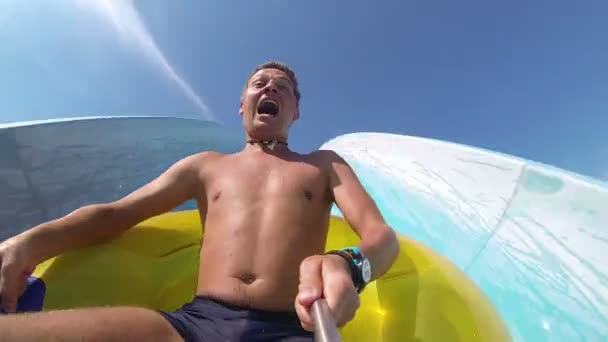 Hombre divirtiéndose, deslizándose en el parque acuático . — Vídeos de Stock