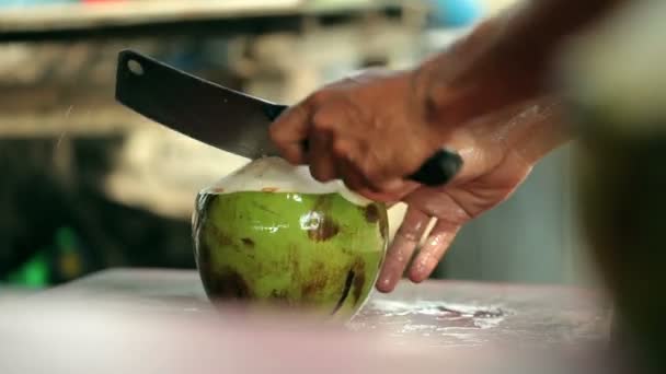 Un homme ouvre la noix de coco avec un gros couteau . — Video