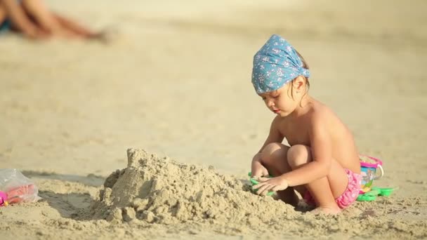 Cute little girl gra z piasku na tropikalnej plaży. — Wideo stockowe