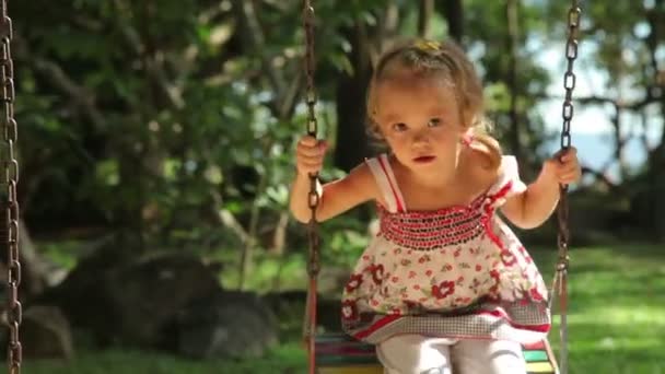Roztomilá dívka na houpačce v parku. Máma a dcera tráví čas v parku. — Stock video