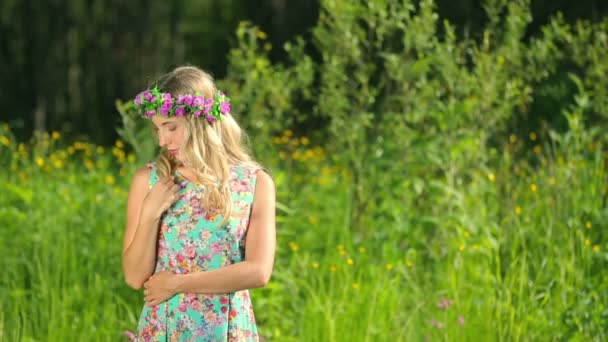 Young beautiful woman with flower wreath at the river. A beautiful girl walks by the river. — Stock Video