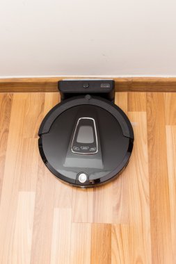Robotic vacuum cleaner on wood parquet floor