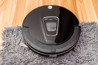 Robotic vacuum cleaner on wood parquet floor