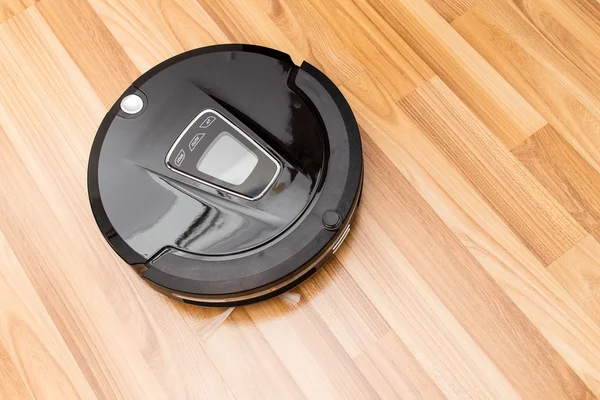 Robotic vacuum cleaner on wood parquet floor. — Stock Photo, Image