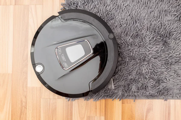 Robotic vacuum cleaner on wood parquet floor