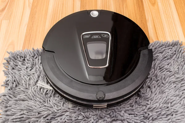 Robotic vacuum cleaner on wood parquet floor
