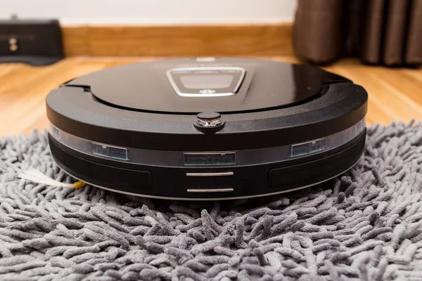 Robotic vacuum cleaner on wood parquet floor