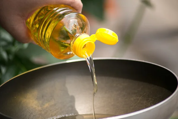 Verser de l'huile alimentaire dans une poêle chaude pour la friture . — Photo