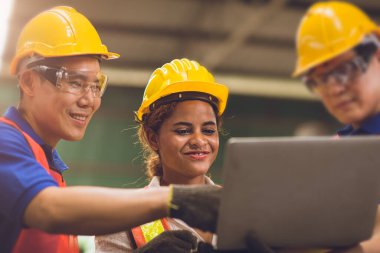 Akıllı kadın mühendis erkeklerle çalışıyor. Yarış takımları ağır sektörde birlikte çalışıyor. Dizüstü bilgisayarda arıyor ve tartışıyorlar..