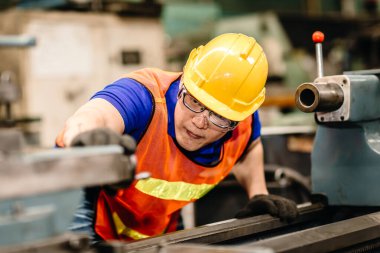 Asian worker work hard eyes focused on machine, people pay attention working in industrial plants.