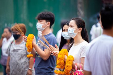 Asian Thai people worship the Buddha in Guan Yin Thien Fah Shrine with flowers, incense and large candles. Chinese temples is a famous tourist destination.18 October 2020, Bangkok,THAILAND.