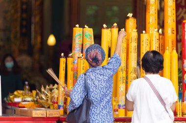 Asian Thai people worship the Buddha in Guan Yin Thien Fah Shrine with flowers, incense and large candles. Chinese temples is a famous tourist destination.18 October 2020, Bangkok,THAILAND.