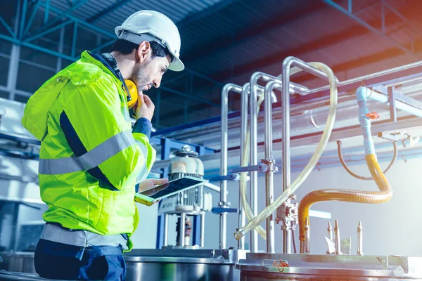 engineer working in factory using tablet computer to check boiler water pipe in factory