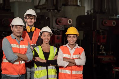 Ekip İşçi karışık yarışı. Ağır fabrikada birlikte çalışmanın keyfini çıkarın. Mutlu bir gülümseme.