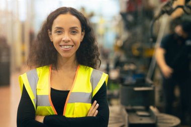 Afro-Amerikalı kadın mutlu işçi mühendisliği gülümsüyor ağır endüstri fabrikasında iyi refah konsepti olan işgücü.