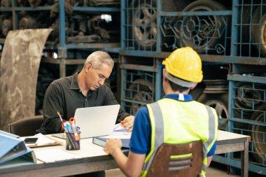 Factory manager looking at the paper with young engineer sitting front for call for blaming or consider and interview job apply or solving working problem report situation at factory work clipart