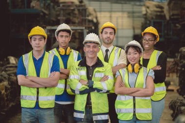 Bir grup endüstri çalışanı işçi mühendis karışık ırk ağır fabrikada birlikte çalışmanın keyfini çıkarın mutlu gülümseme portresi güven takım çalışması kolları çapraz