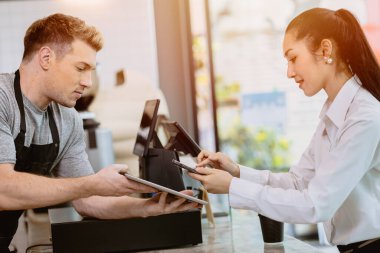 Kafe müşterisi cep telefonu internet bankacılığı kullanıyor. Kahve için QR ödeme kodu. Tezgahtaki barista çalışanlarından. Nakitsiz toplum modern yaşam tarzı kavramı.