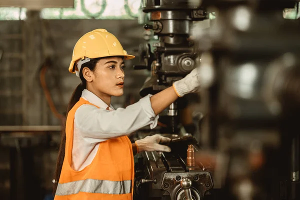 若い女性は 金属工場の職場エンジニアで働く幸せ労働者に出席するメンテナンス重工業機械を修正します — ストック写真