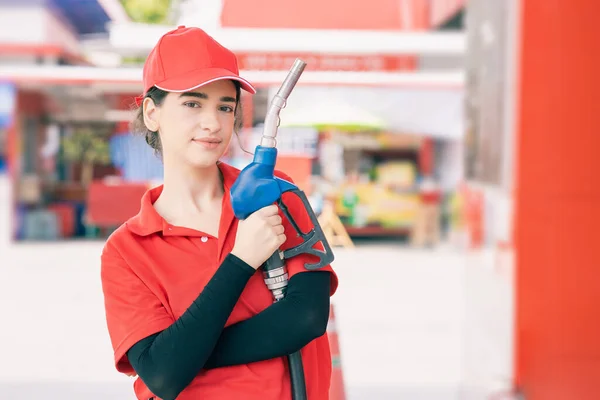 Portrait gas station staff worker women happy smiling with fuel nozzle for car gasoline refill service job.