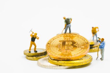Bitcoin madencileri, dijital para veya kripto para kavramını eşeleyen minyatür işçi modelleri. Bozuk para üzerinde çalışan insanlar beyaz arka planda kripto para birimi.