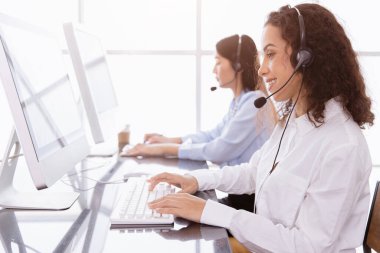 Çağrı merkezi çalışanları yardım hattı ya da Telesale acentesi ya da müşteri desteği için arıyorlar. Ofiste gülümsemeyle çalışmaktan mutlular..