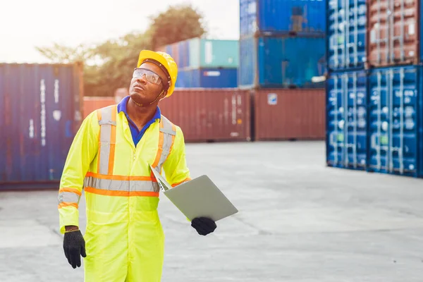 从事物流运输的非洲黑人快乐工作者 在港口货物装卸集装箱时使用笔记本电脑进行计算机控制 进出口航运业人士 — 图库照片