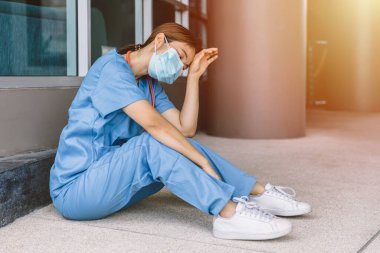 Hemşire çok yorgun ve yorgun. Coronavirus (COVID-19) salgınından bitap düşmüş doktor ve tıbbi personel hastanede.